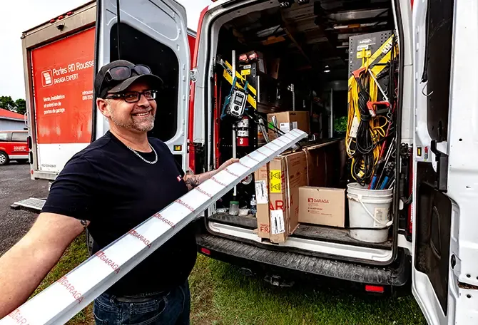 Installateurs de Portes RD Rousseau remplissant leur camion pour aller effectuer la réparation des portes de garage agricoles d'une ferme de St-Wenceslas